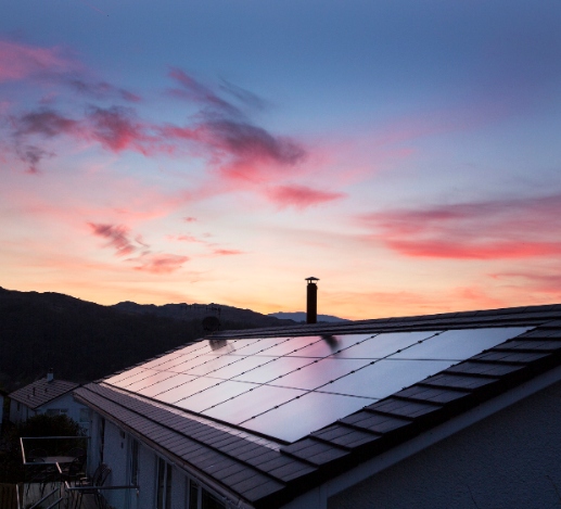 solar panels on the roof of a house during a beautiful sunset