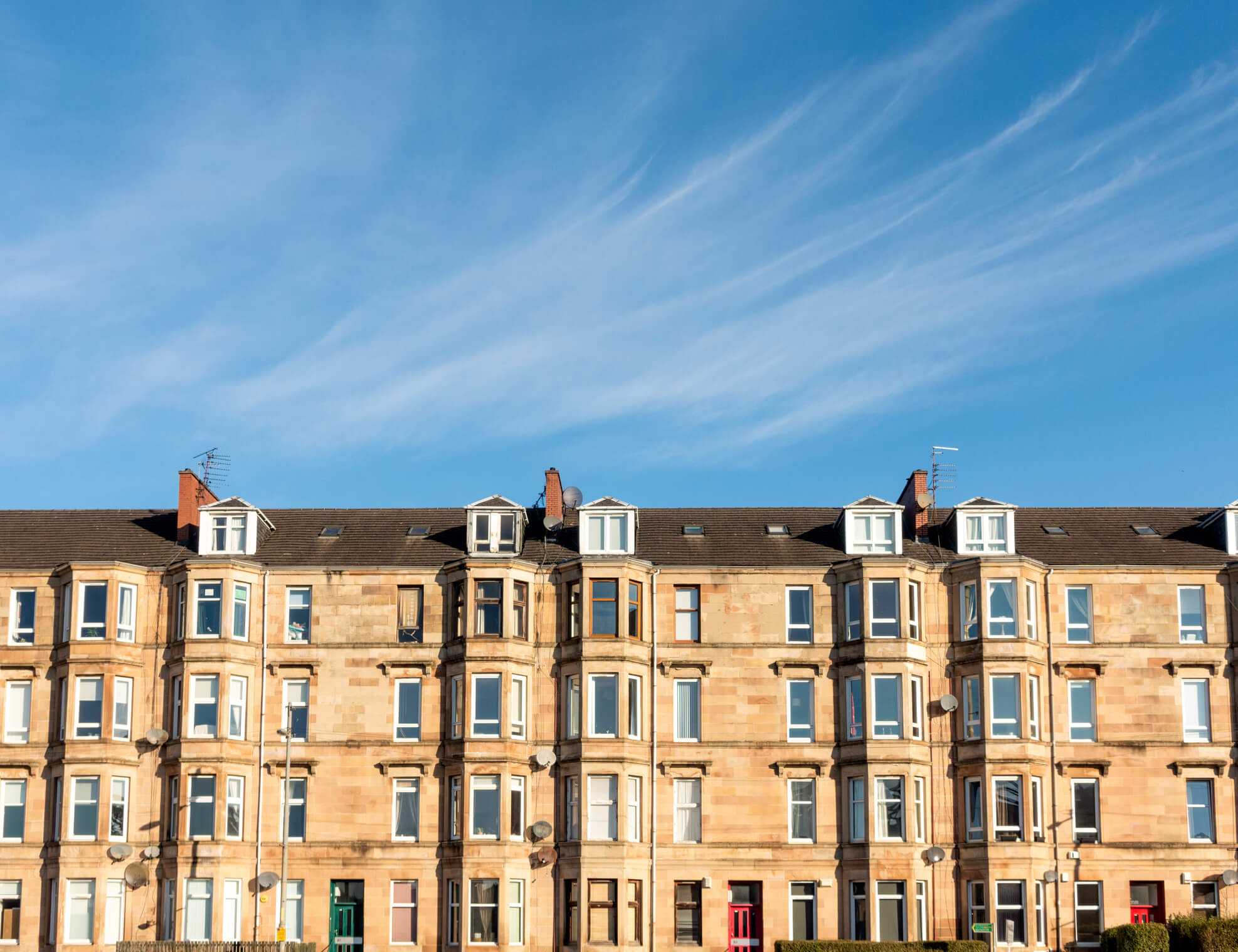 Tenement flats in Edinburgh against a blue sky