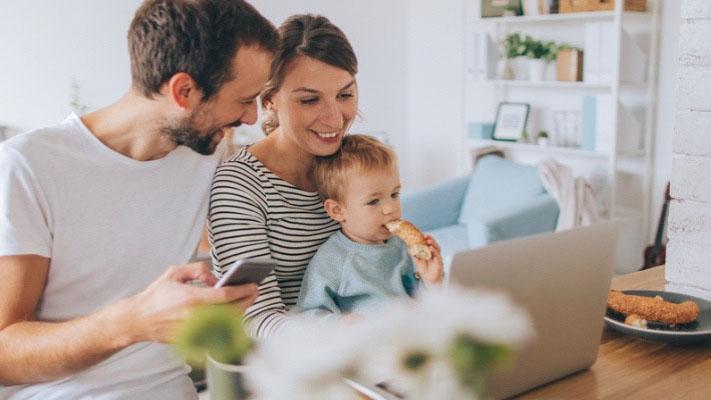 Young family looking at their computer 